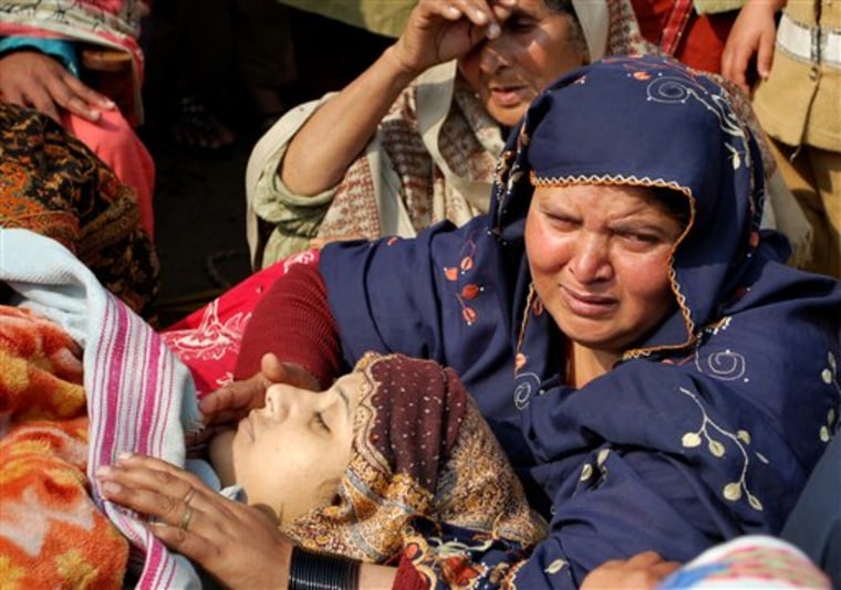 Family members attend the body of Shumaila Kanwal, the widow of a Pakistani man allegedly shot and killed by a U.S. official, in Chak Chumra near Faisalabad, Pakistan on Monday. Kanwal committed suicide by taking insecticides Sunday, saying she was driven to act by fears that the American would be freed without trial.